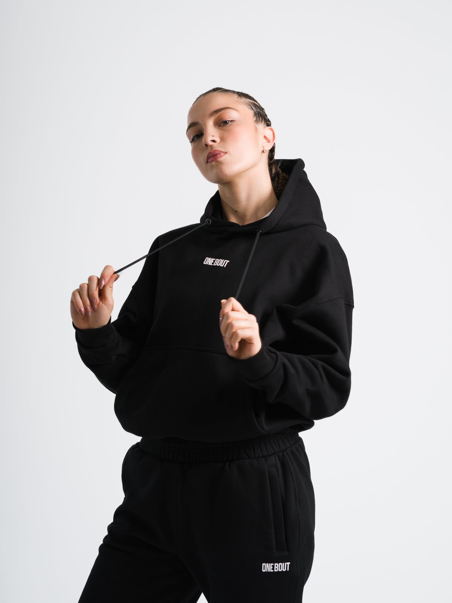 Female model wearing black ONE BOUT Script Oversized Hoodie